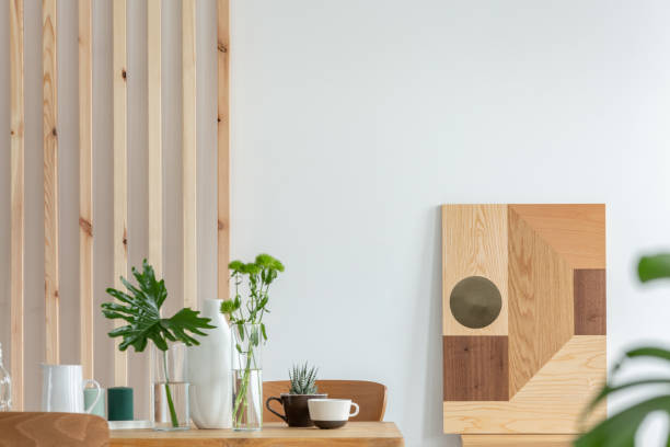 istock Green plants in small vases on long wooden dining table in bright interior 1215325835