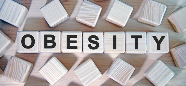 OBESITY - text wooden cubes and many cubes around