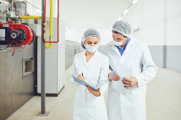 istock Two technologists in lab coats and masks at the factory. 1215329702