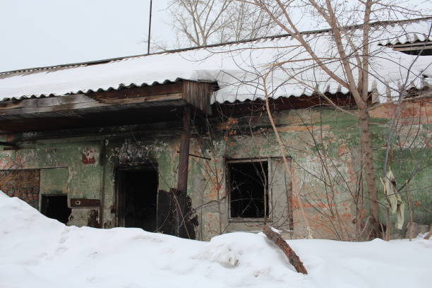 istock abandoned destroyed building with broken Windows dangerous ruins in winter in the snow 1215329721