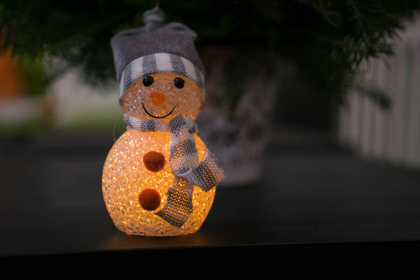 istock Illuminating snowman decoration in a hat and scarf 1215329948