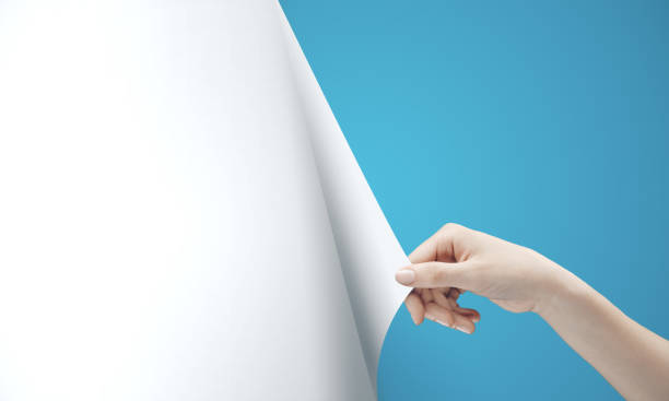 istock Woman hand turning blue page 1215331790