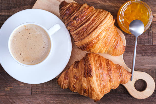 istock Directly above cap coffee cappuccino and croissant and jam 1215332016