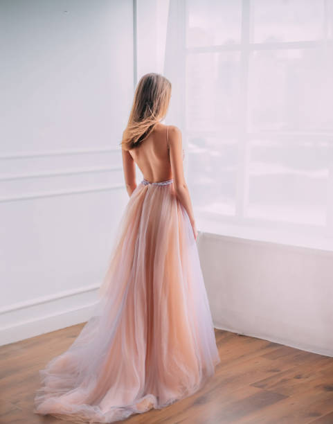 таинственная молодая женщина принцесса в элегантной красивой воздушной роскоши длинное вечернее модное платье, голая открытая спина. секс - evening gown стоковые фото и изображения