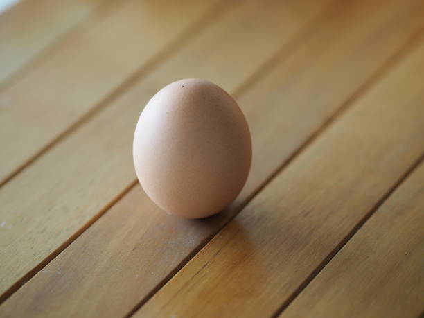 istock Fresh egg on brown wooden desk 1215335122