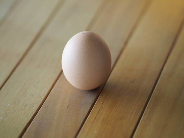 istock Fresh egg on brown wooden desk 1215335123