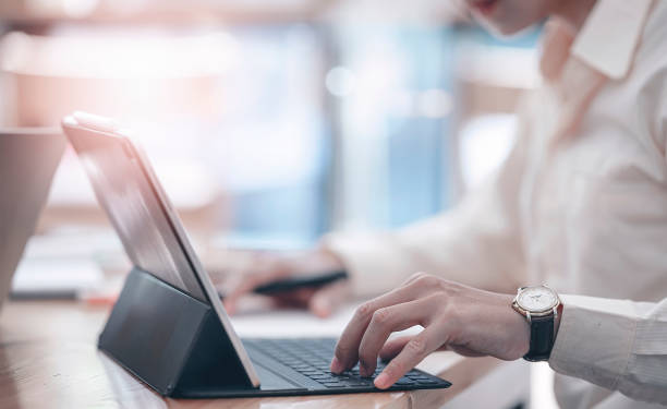 istock Cropped shot of businessman using and typing on computer keyboard while sitting at office desk. 1215336209