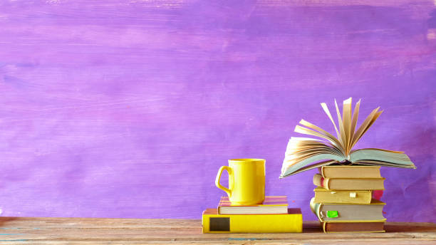 istock Stacks of  books and open book. Reading, education at home, learning, reading a book concept. Corona virus, covid-19 lockdown. 1215337642