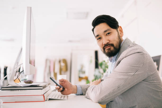 istock Man sitting behind the desk, smiling 1215339144