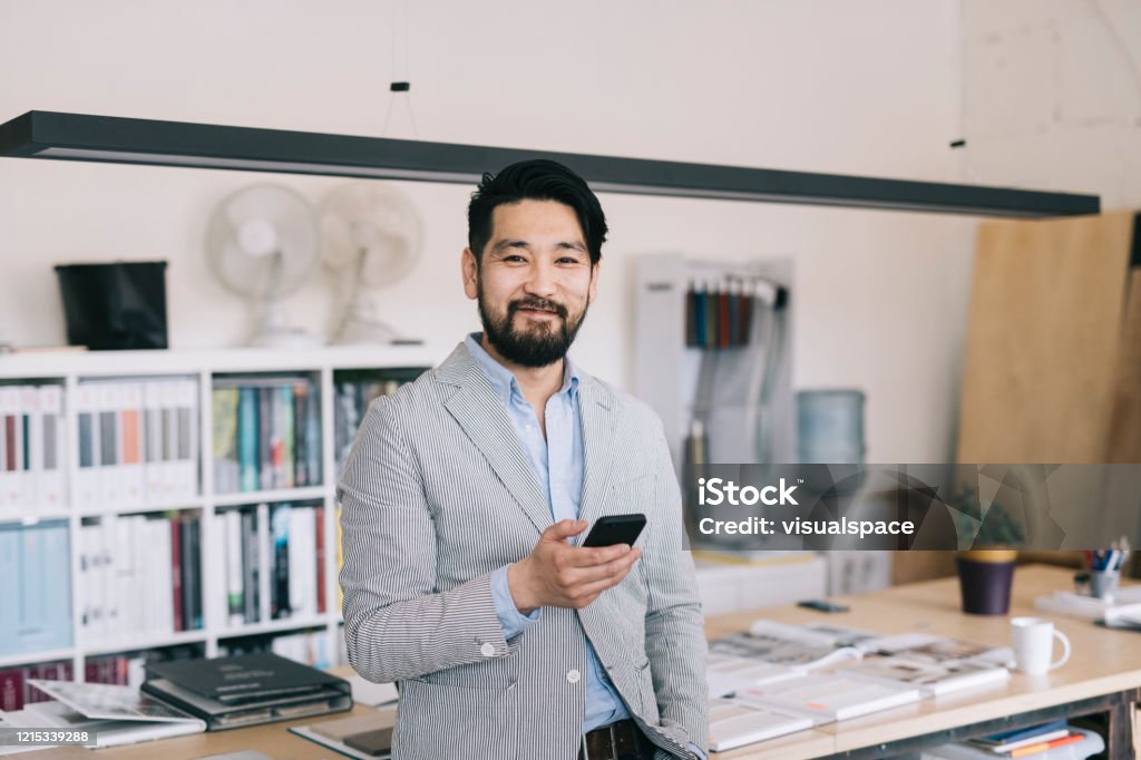 Portrait at the office Portrait of happy and proud Asian man at his offfice Owner Stock Photo