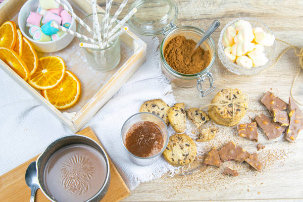 istock Spicy hot chocolate with cinnamon stick and chocolate chip cookies with dried orange over wooden background 1215339607