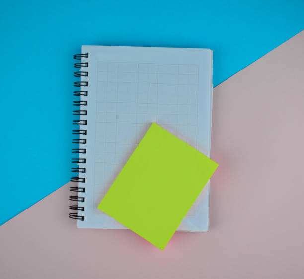 istock Some light green sticky notes on top of a white paper diary before a blue-pink paper background 1215346305