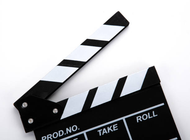 istock black movie clapper with white inscriptions on a white table closeup 1215346947