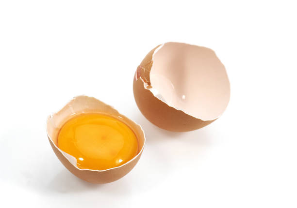 istock CHICKEN EGG SHOWING YOLK AGAINST WHITE BACKGROUND  . 1215348019
