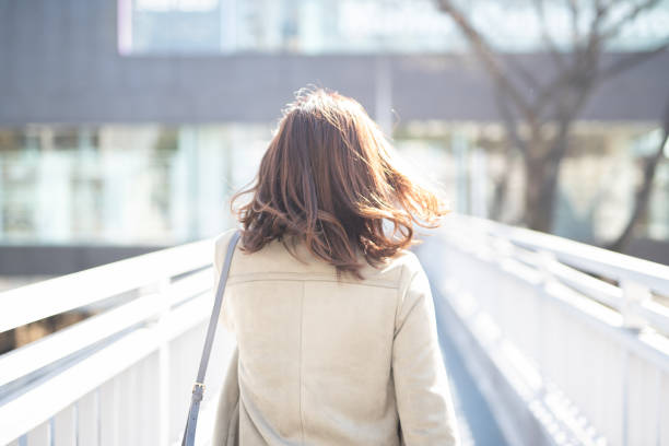 Rear view of businesswoman walking on footbridge Asian young woman walking on the street in Harajuku, famous commercial district of Tokyo, Japan footbridge stock pictures, royalty-free photos & images