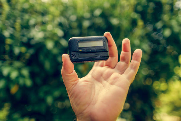 istock pager, old vintage beeper. pager in hand 1215349998
