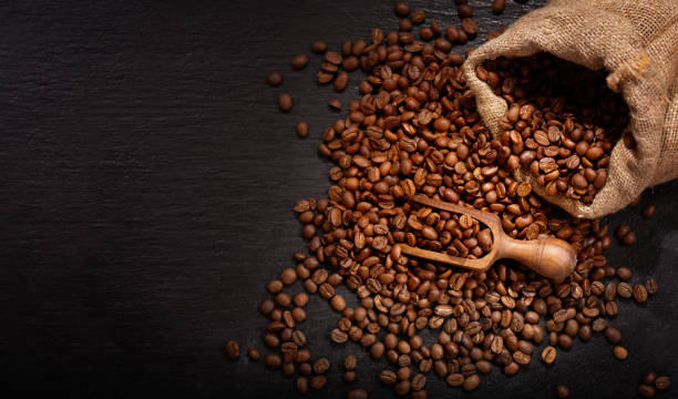 istock Coffee beans in a sack on dark table 1215352581