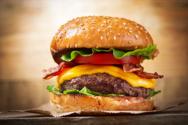 istock burger with cheese, bacon, salad and vegetables 1215353181