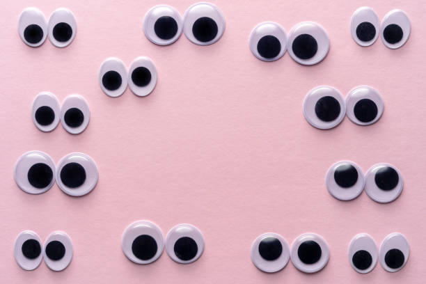 istock Creative layout of many googly eyes on pink background. Minimal concept. 1215356644