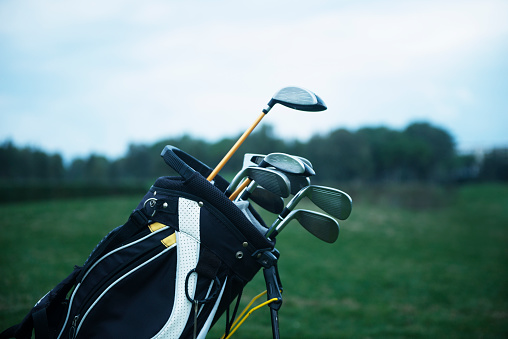 Close-up shot of a golf bag in a golf course. Horizontal shot.