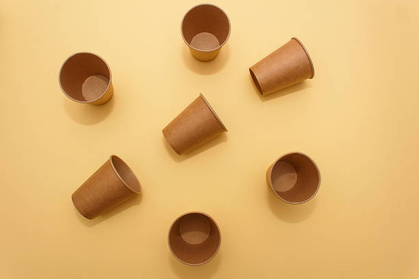 istock Many craft paper cups for coffee on a  yellow  background 1215366494