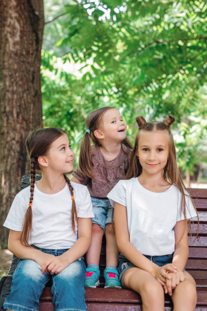 istock Three sisters smiling and hugging outdoors in summer park. 1215366764