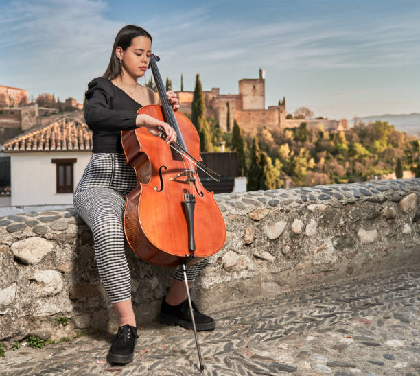 femme jouant le violoncelle dans l’un des plus beaux endroits dans le monde - musical theater music antique musical note photos et images de collection