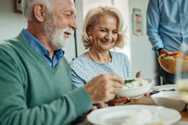 szczęśliwa starsza kobieta i jej mąż korzystających w porze lunchu przy stole. - dining senior adult friendship mature adult zdjęcia i obrazy z banku zdjęć