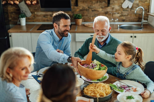 istock Smiling multi-generation family enjoying in a lunch in dining room. 1215369727