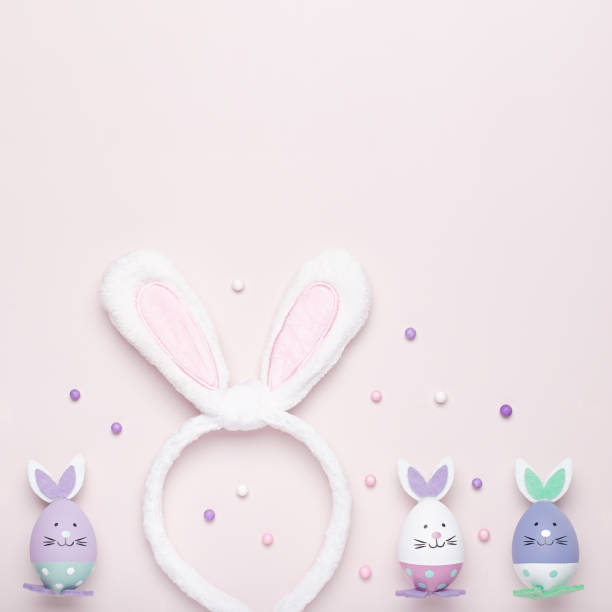 funny kawaii cute bunny eggs and bunny rabbit ears for kids in pastel colors on pink table top, easter holiday concept. easter decoration for kids still life, copy space - 7298 imagens e fotografias de stock