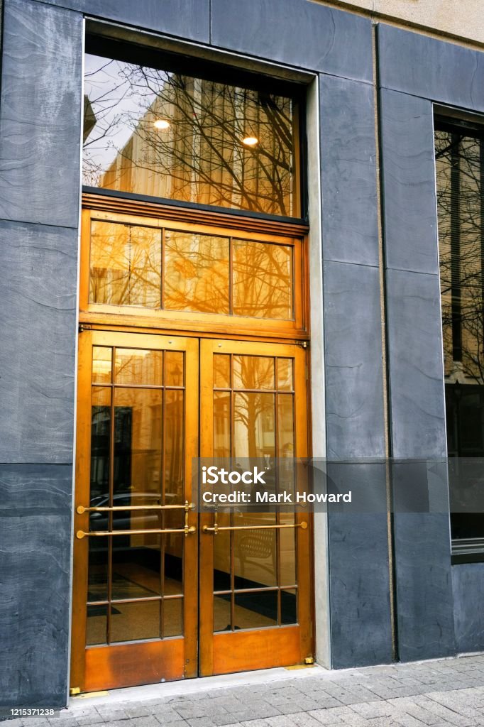 Brass Double Doors The entrance of a building with double brass doors. Intercom Stock Photo