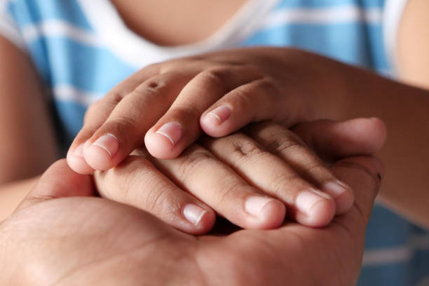 istock father hand holding child hand, close up 1215371798