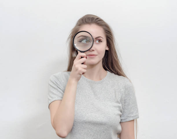 istock Nice girl examines something in a magnifying glass. 1215371944