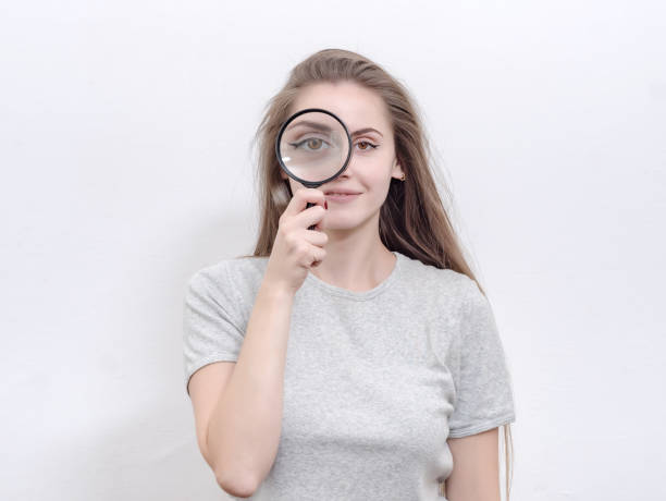 istock Nice girl examines something in a magnifying glass. 1215371947