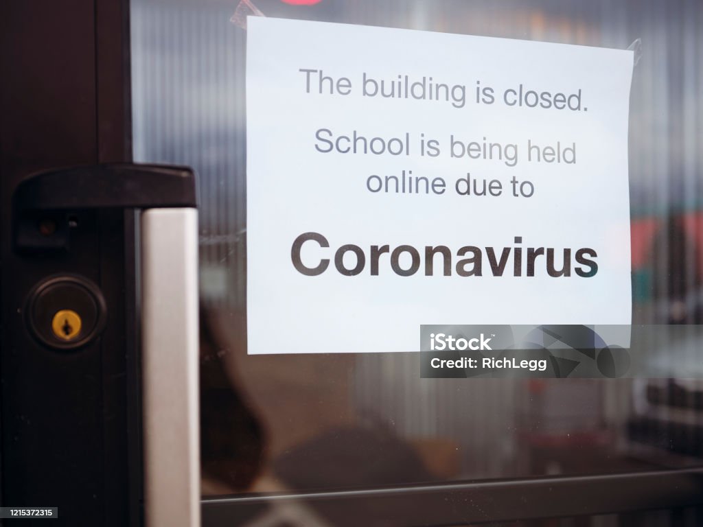 COVID-19 Coronavirus School Closed A door to a school with a sign stating that it is closed by the Coronavirus COVID-19 pandemic. School Building Stock Photo