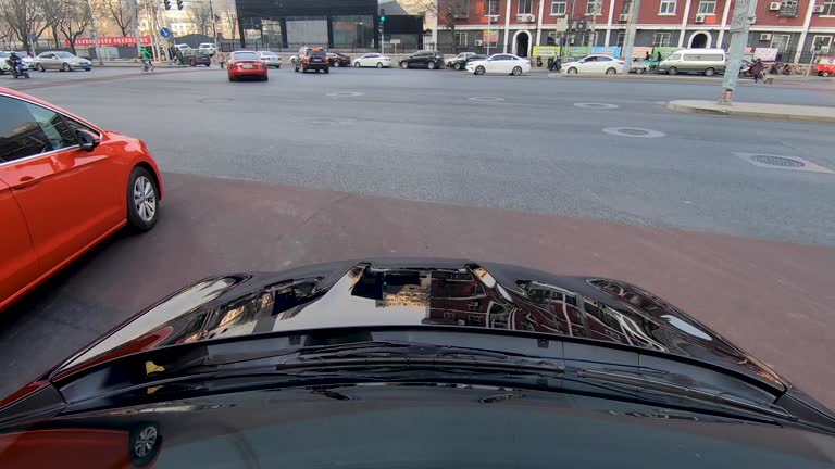 Front view car vehicle driving on downtown city road during day. Beijing, China