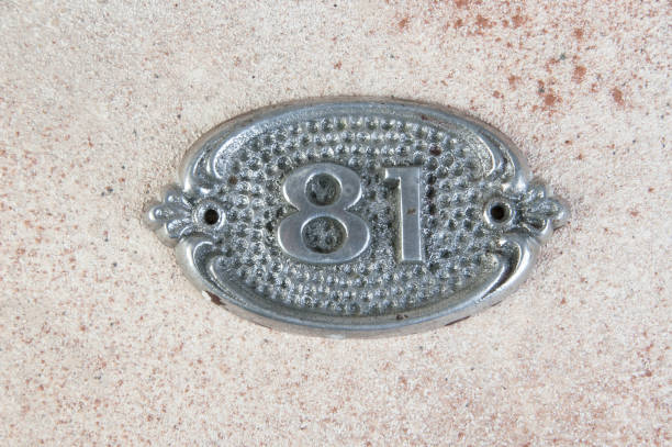 Old aluminum number on concrete background