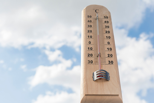 Thermometer against sky as a concept of ambient temperature