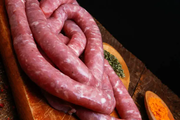 Traditional Brazilian sausage, manufactured in Braganca Paulista, state of Sao Paulo, Brazil. With seasoning on rustic wooden table