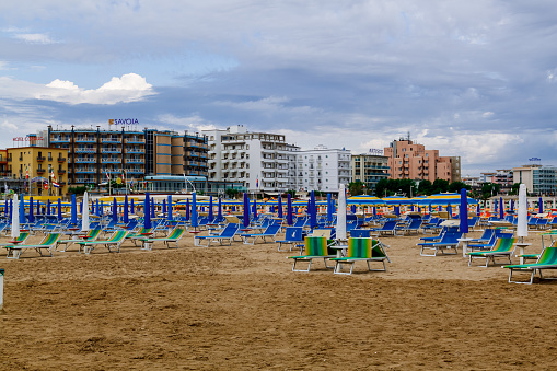 Rimini, Italy - June 20 2016: Empty beach with sunbeds and umbrellas on an early cloudy morning.