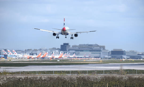 A British Airways Airbus A319-131 callsign G-DBCA comes into land at Gatwick Airport over many grounded aeroplanes due to the Covid-19 coronavirus pandemic. London Gatwick Airport, UK - March 28 2020: A British Airways Airbus A319-131 callsign G-DBCA comes into land at Gatwick Airport over many grounded aeroplanes due to the Covid-19 coronavirus pandemic. gatwick airport photos stock pictures, royalty-free photos & images