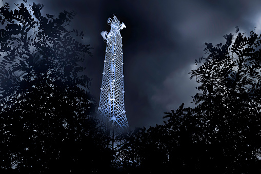 Large cellular communications tower at night. Radio antenna tower.