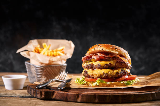 Set of hamburger and french fries. A standard set of drinks and food in the pub, beer and snacks. Dark background, fast food. Traditional american food stock photo