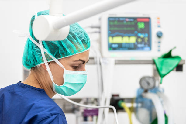 covid-19 outbreak. healthcare worker. nurse working in intensive care unit. mechanical ventilation system in the background. - surgeon urgency expertise emergency services imagens e fotografias de stock