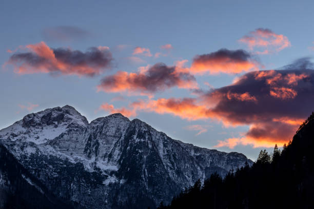 istock Orange sundown clouds above snowy mountains at winter 1215386547