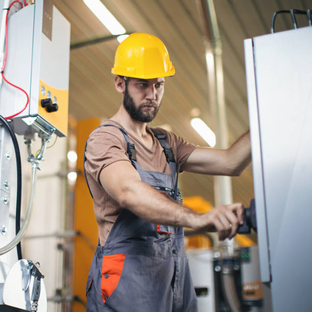 istock Young man in the factory using and checking machines 1215389109
