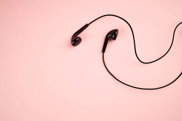 istock black earphone isolated on a pink pastel backdrop. flat lay. outer space. music minimalism concept 1215394501