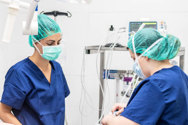 covid-19 outbreak. healthcare worker. nurse working in intensive care unit. mechanical ventilation system in the background. - surgeon urgency expertise emergency services imagens e fotografias de stock