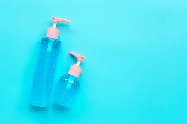 istock Alcohol hand sanitizer gel in pump bottles on blue background. Copy space 1215400213