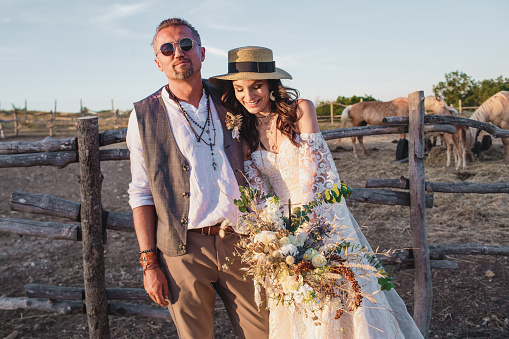 Wedding couple in the boho style on the ranch. Designer wedding bouquet in the style of boho.